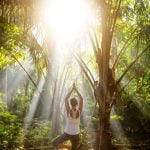 Chi insegna lo yoga: praticante in posa di loto all'aperto